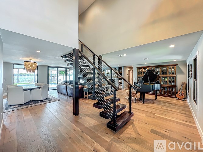 A spacious living room with a staircase and a dining area.