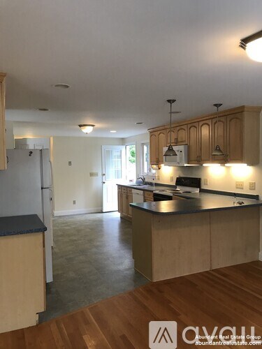 A kitchen with wooden cabinets and a black countertop.