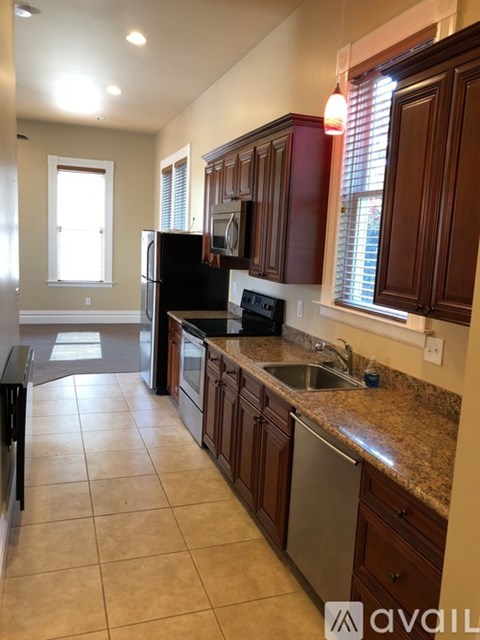 A kitchen with brown cabinets and a granite countertop.