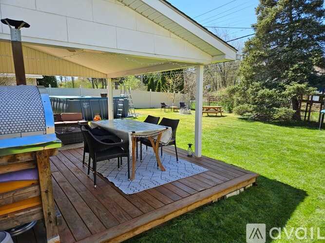A patio with a table and chairs under a roof.