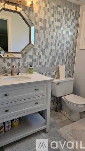 A bathroom with a toilet, sink, and mirror.