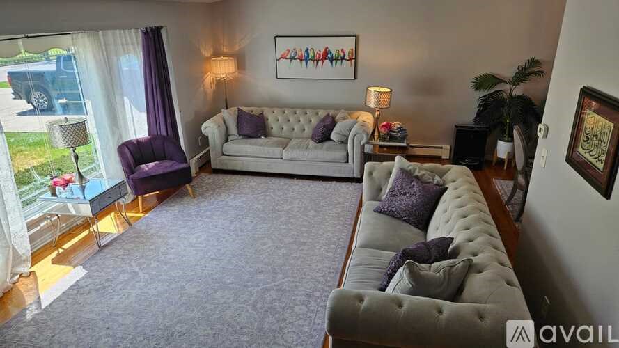 A living room with a grey sofa and a purple chair.