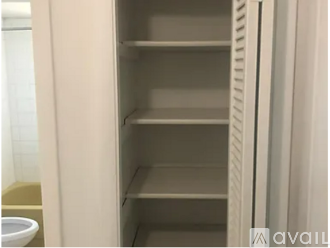 Empty white shelves in a refrigerator.
