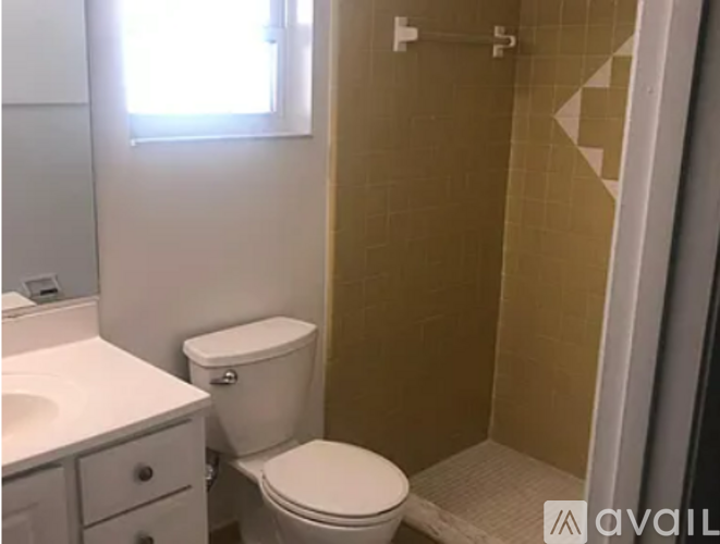 A bathroom with a toilet, sink, and shower.