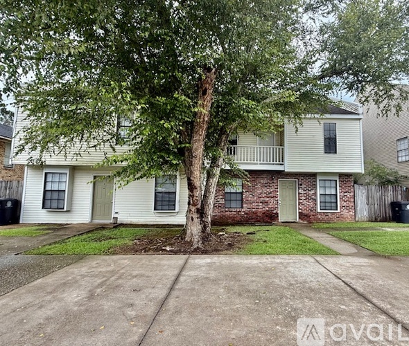 A tree in front of a house with a sign that says "available".