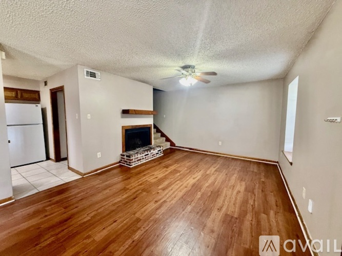 A living room with a fireplace and wooden floors.