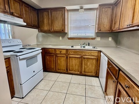 A kitchen with wooden cabinets and a white stove.
