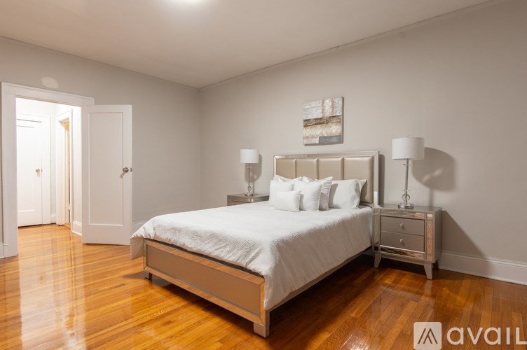 A bedroom with a bed, nightstand, and lamp.