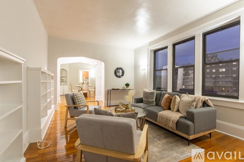 A living room with a grey couch and a wooden floor.