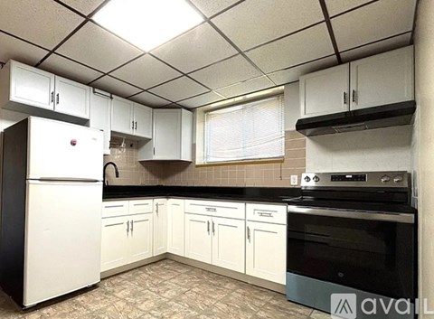 A kitchen with white cabinets and black appliances.