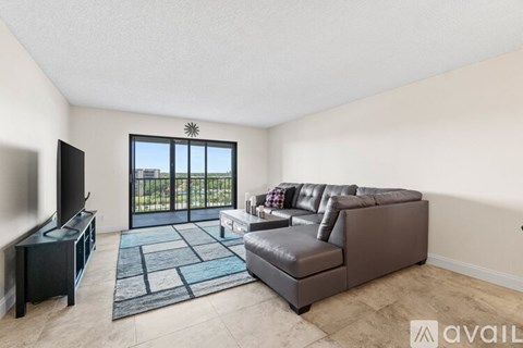 A living room with a brown leather couch and a flat screen TV.