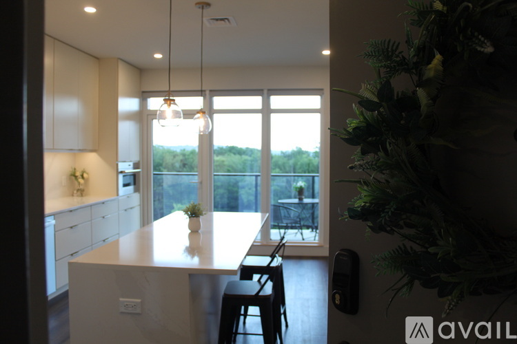 A modern kitchen with a marble island and pendant lights.
