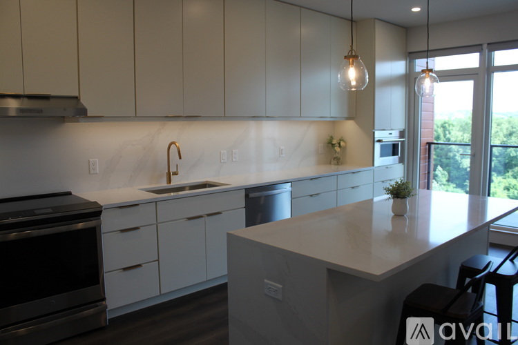 A kitchen with white cabinets and a marble backsplash.