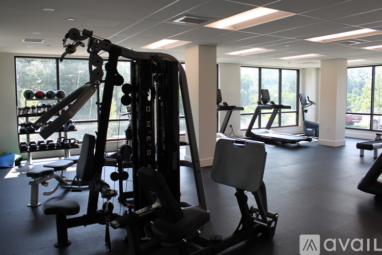 A gym with a variety of equipment including a weight machine and a bench.