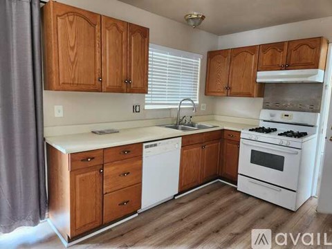 A kitchen with wooden cabinets and white appliances.