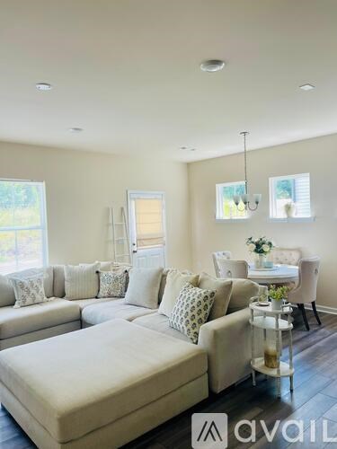 A living room with a white couch and a glass coffee table.