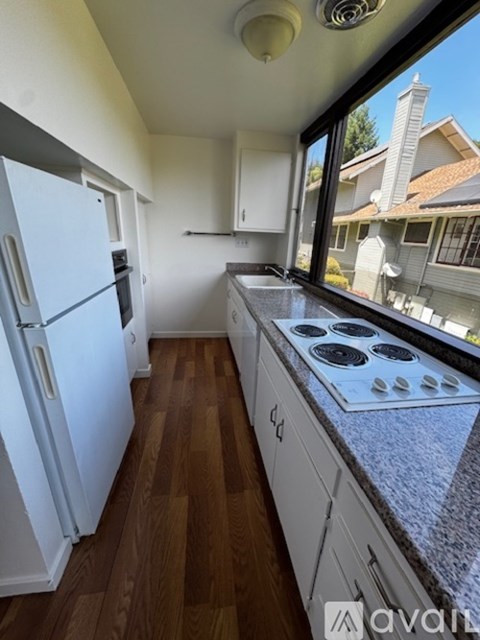 A kitchen with a white fridge and a white stove top.