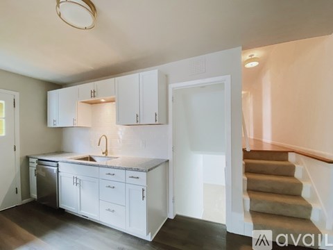 A kitchen with white cabinets and a stainless steel dishwasher.