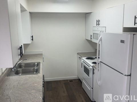 A kitchen with white appliances and cabinets.