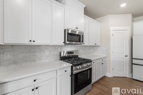 A kitchen with white cabinets and a black stove top oven.