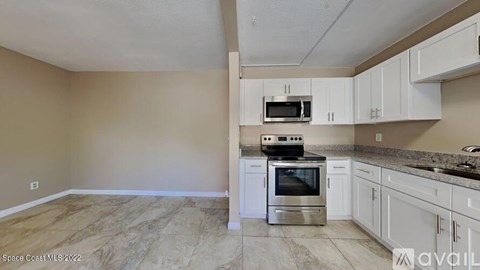 A kitchen with a stove top oven and microwave built into the cabinetry.