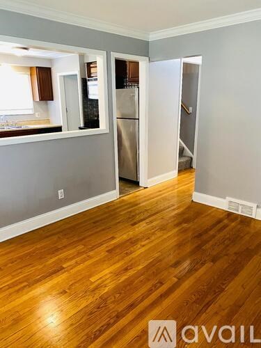 A kitchen with a refrigerator and a view of a dining area.