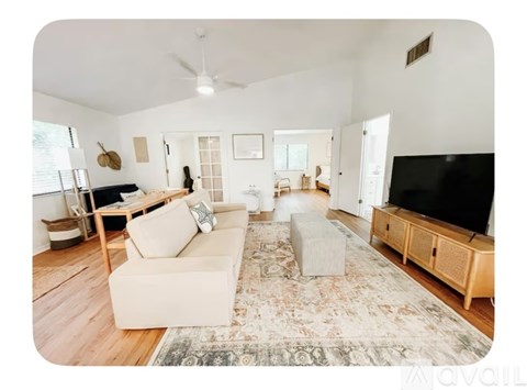 A living room with a white couch and a rug.