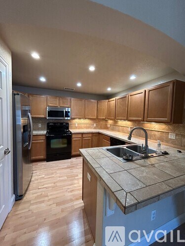 A kitchen with wooden cabinets and a granite countertop.
