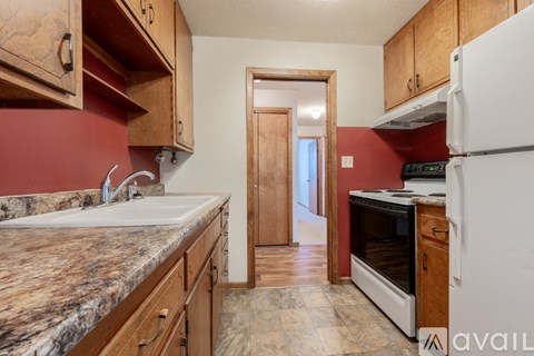 A kitchen with wooden cabinets and a marble countertop.