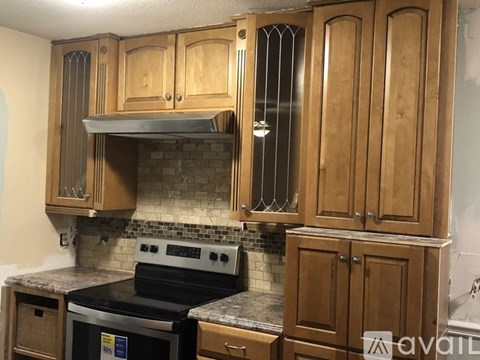 A kitchen with wooden cabinets and a black stove top oven.