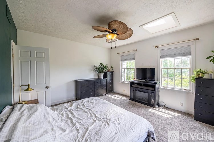 A bedroom with a bed, dresser, and television.