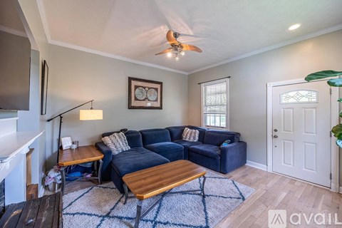 A living room with a blue couch and a wooden coffee table.