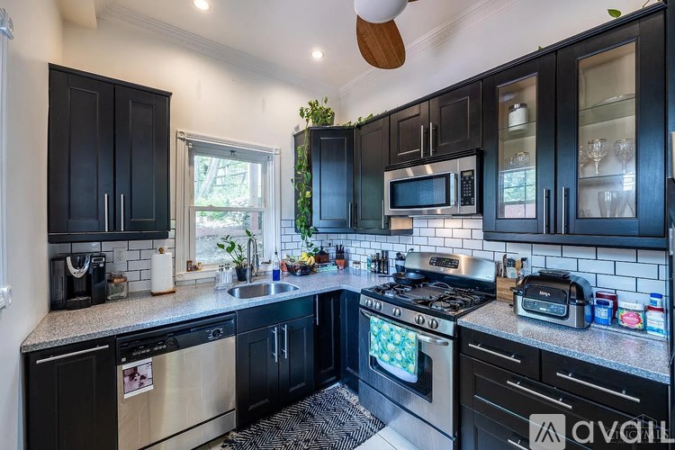 A kitchen with black cabinets and stainless steel appliances.