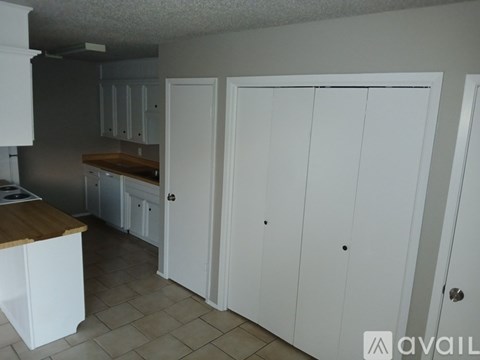 A kitchen with white cabinets and a wooden island.