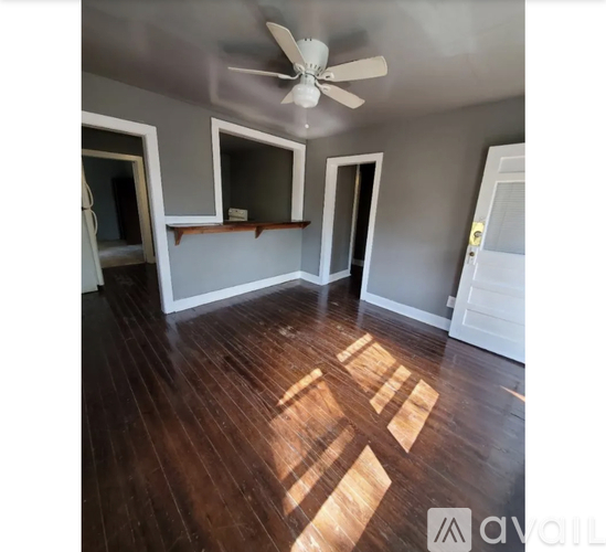 A room with wooden floors and a ceiling fan.