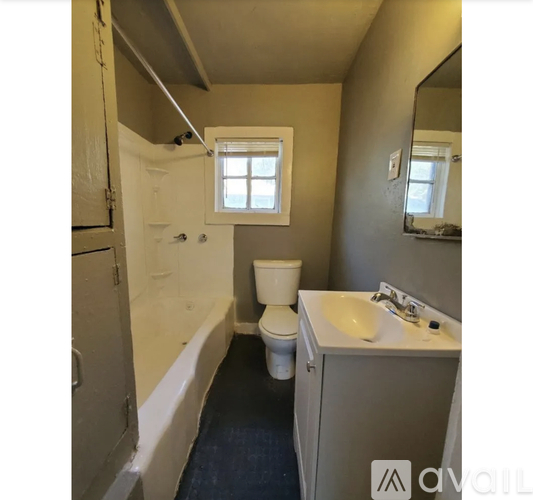 A small bathroom with a toilet, sink, and a window.