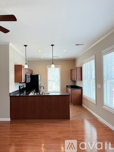 A kitchen with wooden cabinets and a black countertop.