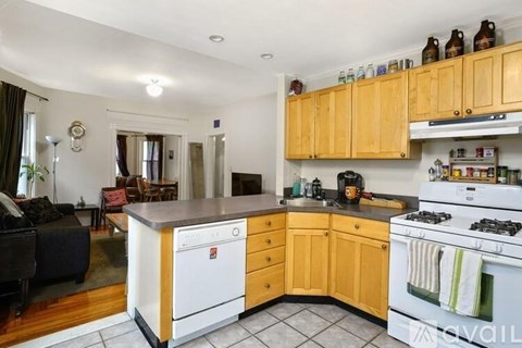 A kitchen with wooden cabinets and a white stove top oven.