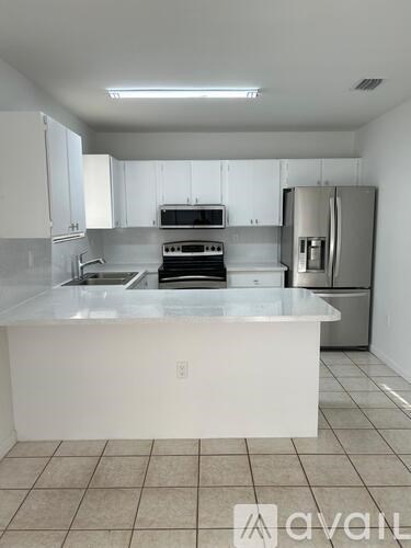 A kitchen with white cabinets and appliances.