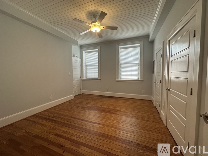 A room with wooden floors and a ceiling fan.