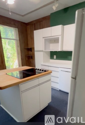A kitchen with white cabinets and a white fridge.