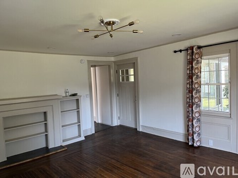 A room with a ceiling fan and wooden floors.