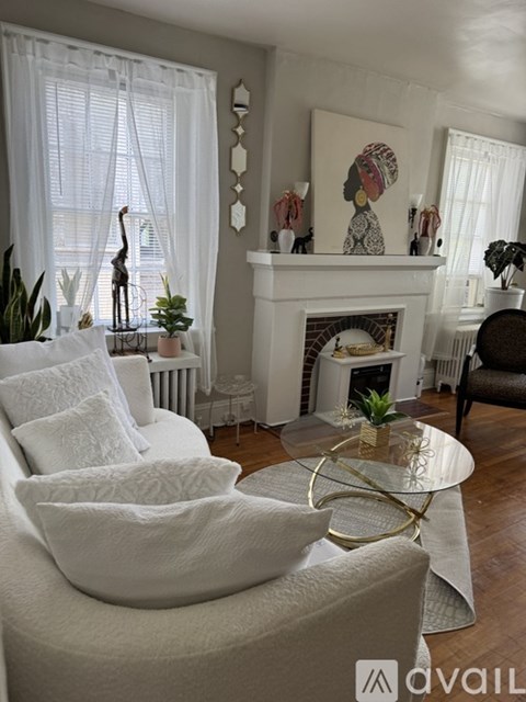 A living room with a white couch and a fireplace.