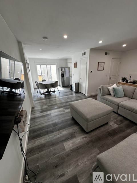 A living room with a grey couch and a wooden floor.