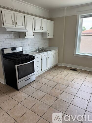 A kitchen with a black stove top oven and white cabinets.