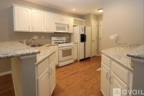 A kitchen with white cabinets and granite countertops.