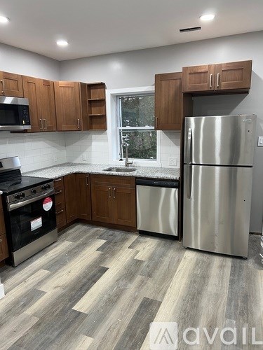 A kitchen with wooden cabinets and a stainless steel refrigerator.