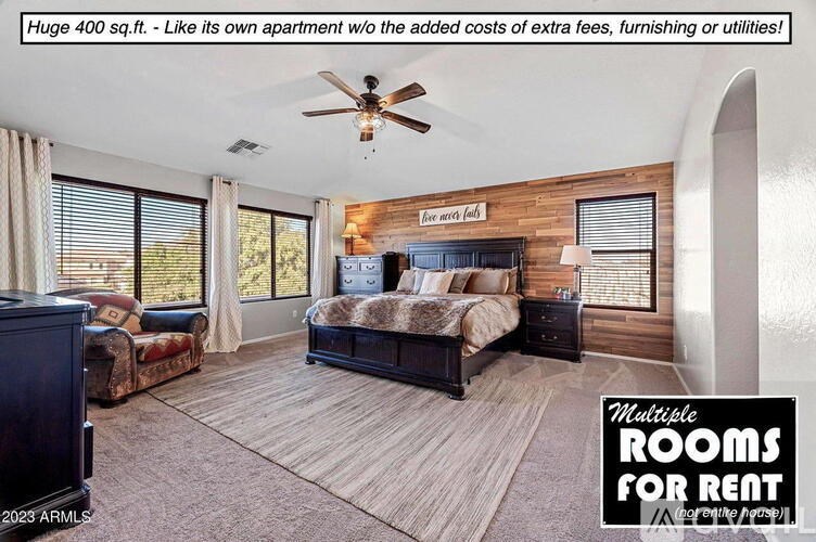 A large bedroom with a bed, dresser, and couch is for rent.