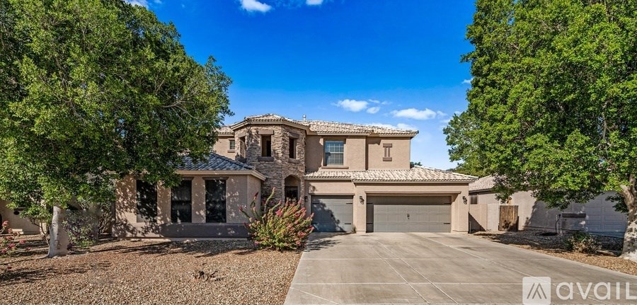 A house with a driveway and trees in front of it.