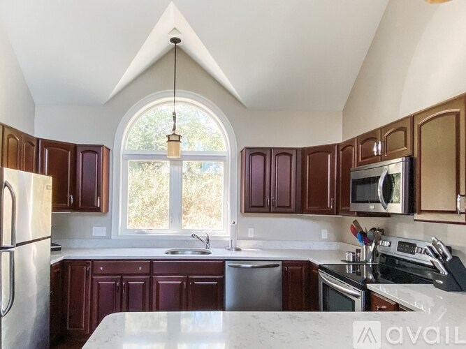 A kitchen with brown cabinets and a white counter top.